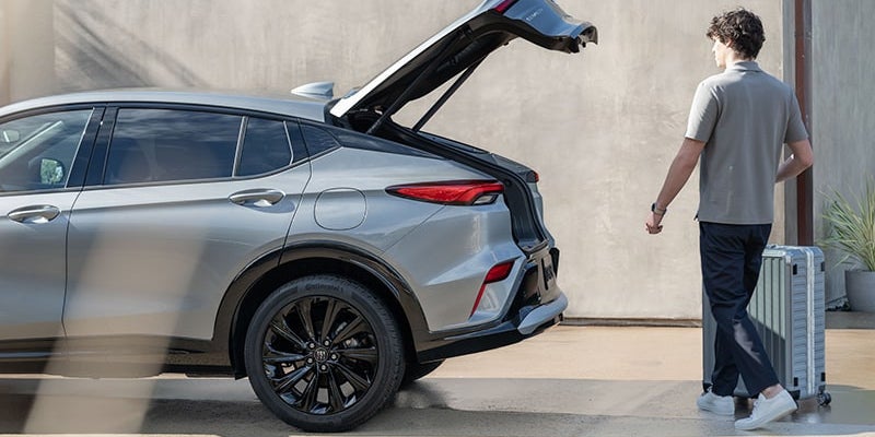 2025 Buick Envista with trunk open and person with a suitcase walking towards it